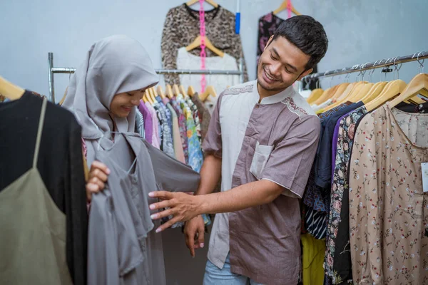 Muslimische Frau kauft mit ihrem Mann ein Kleid für idul fitri — Stockfoto