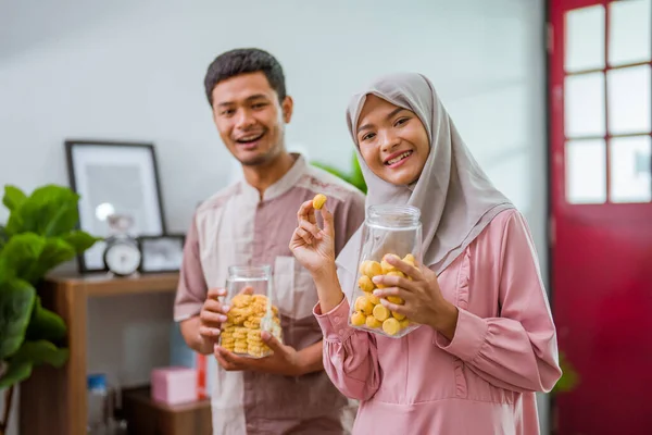 Pareja musulmana sosteniendo idul fitri snack en el frasco —  Fotos de Stock