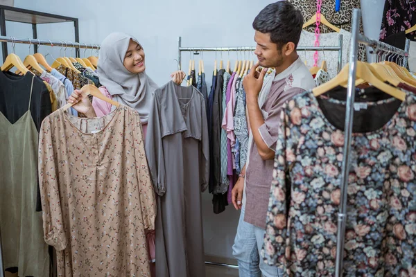 Mulher muçulmana comprando algum vestido para idul fitri com seu marido — Fotografia de Stock