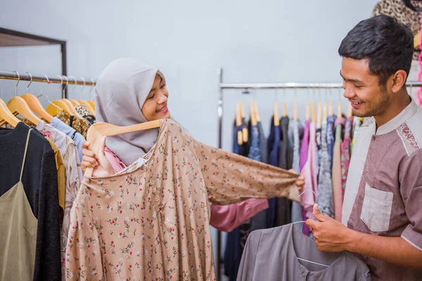 Muslim woman shopping some dress for idul fitri with her husband — стоковое фото