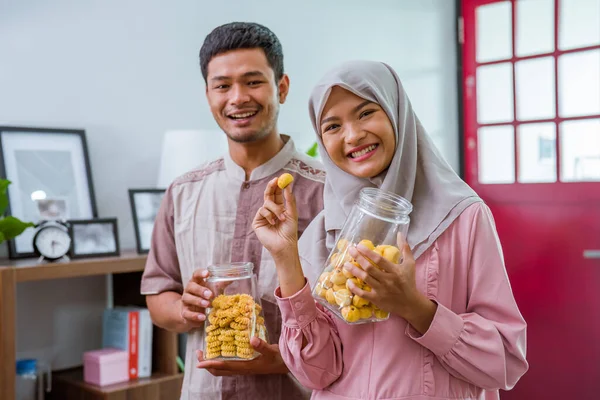 Muslim pasangan memegang idul fitri snack tersenyum ke kamera — Stok Foto