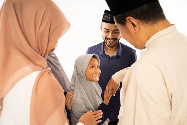 Muslim family shake hand on idul fitri celebration — стоковое фото