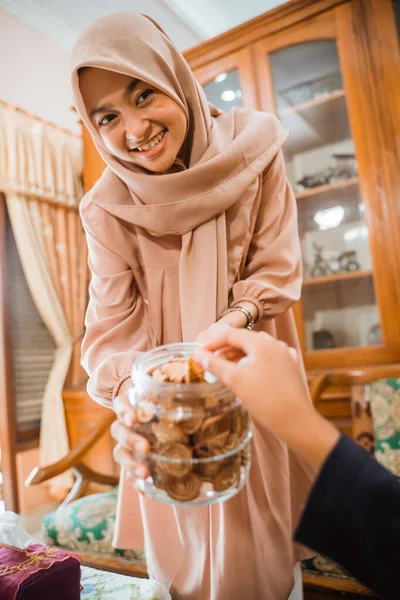 Mulher dando um lanche para seu convidado durante a visita da família idul fitri — Fotografia de Stock