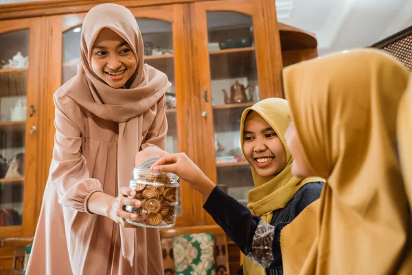 Perempuan memberikan makanan ringan kepada tamunya selama kunjungan keluarga Idul Fitri — Stok Foto