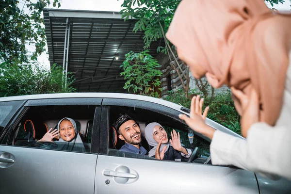 Familie thuiskomen bij hun ouders huis met de auto tijdens idul fitri — Stockfoto