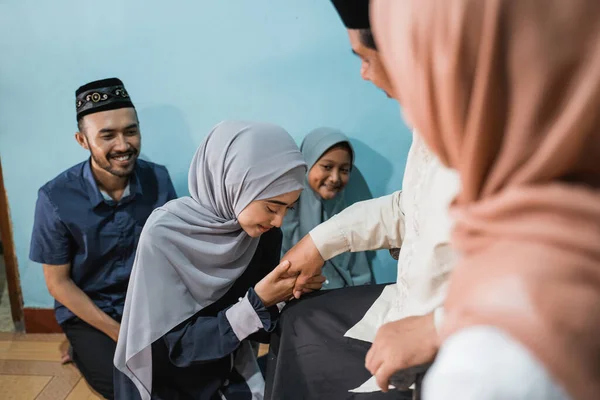 Figlia musulmana inginocchiarsi e stringere la mano dei genitori chiedendo perdono — Foto Stock