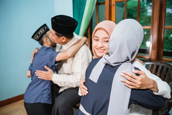 Família muçulmana ajoelhados e abraçando perdoando uns aos outros durante eid mubarak — Fotografia de Stock
