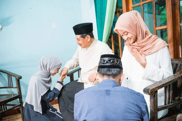 Children visiting their parent and shake hand on idul fitri — Stock Photo, Image