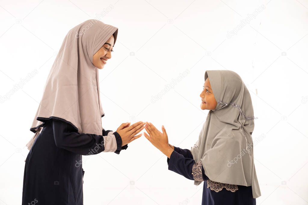daughter shake her mothers hand with traditional gesture