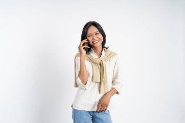 Kadın izole edilmiş bir arka planda cep telefonuyla arama yapıyor.