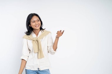 El hareketleriyle genç Asyalı kadın bir şey sunuyor.