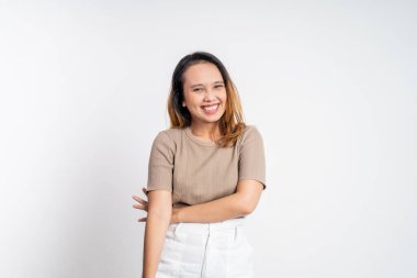 Asyalı kadın kameraya bakıyor çapraz kolla gülümsüyor.