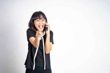 Genç Asyalı bir kadın telefon ederken gülüyor.