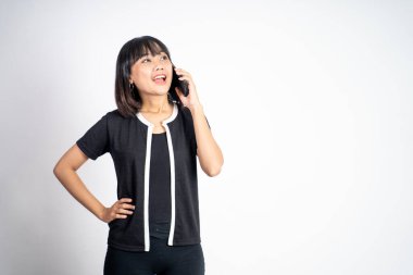 Kadın izole edilmiş bir arka planda cep telefonuyla arama yapıyor.