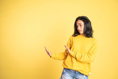 İki avuç içinde reddeden kadın, izole bir arka planda hareket ediyor.