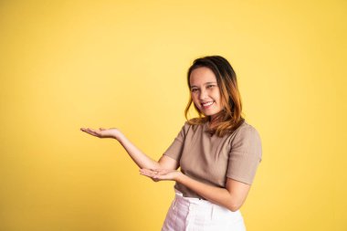 El hareketleriyle genç Asyalı kadın bir şey sunuyor.