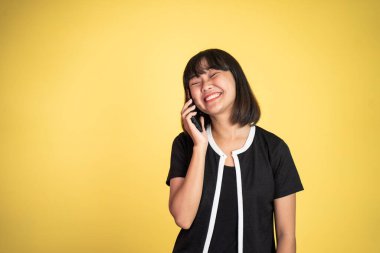 Kadın izole edilmiş bir arka planda cep telefonuyla arama yapıyor.