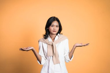 El hareketleriyle genç Asyalı kadın bir şey sunuyor.