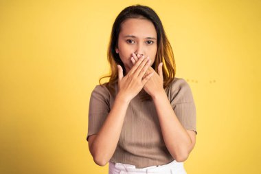 Asyalı bir kadının elleriyle ağzını kapattığı portresi.