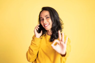 Cep telefonu kullanan genç bir kadın.