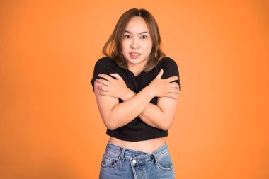 Kadın üşümüş, iki eli de kollarında.