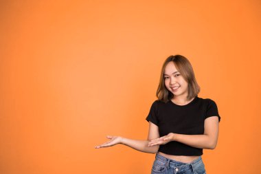 El hareketleriyle genç Asyalı kadın bir şey sunuyor.