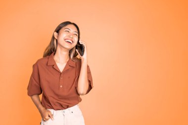 Kadın izole edilmiş bir arka planda cep telefonuyla arama yapıyor.