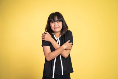 Kadın üşümüş, iki eli de kollarında.