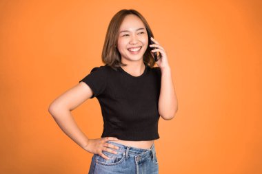 Kadın izole edilmiş bir arka planda cep telefonuyla arama yapıyor.