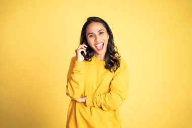 Kadın izole edilmiş bir arka planda cep telefonuyla arama yapıyor.