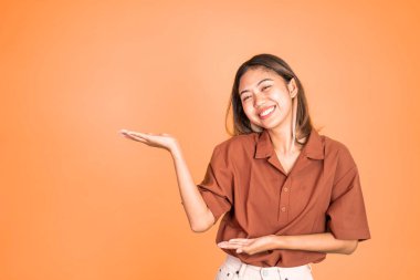 El hareketleriyle genç Asyalı kadın bir şey sunuyor.