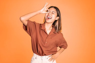 Dürbünü taklit eden elleri göz hizasında olan bir kadın.