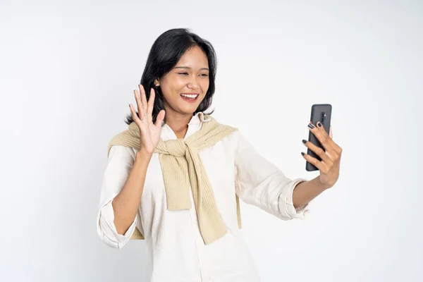 Woman make a video call using mobile phone with saying hello gesture — Stock Photo, Image
