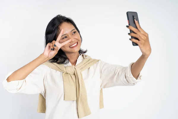 Jonge vrouw selfie met behulp van mobiele telefoon camera met v teken — Stockfoto