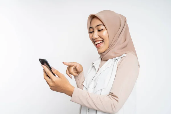 Heyecanlı Asyalı kadın cep telefonunu işaret ederek gülüyor — Stok fotoğraf