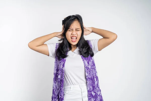Woman with annoyed expression covering ears with both hands — Fotografia de Stock