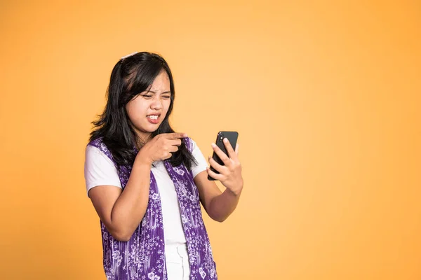 Mad asian young woman while using mobile phone — Stockfoto