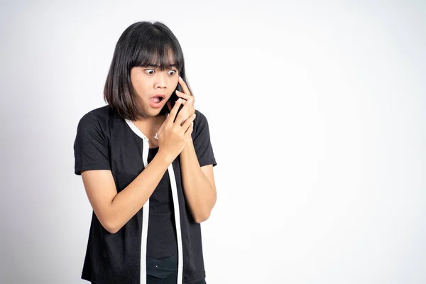 Shocked asian woman making a call using a cell phone — Stockfoto