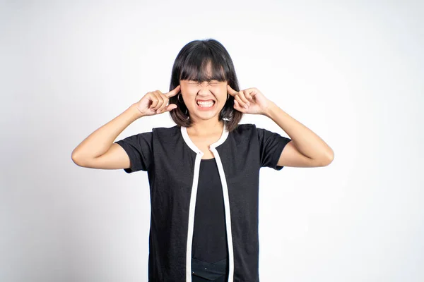Kvinna med irriterad uttryck täcker öronen med båda händerna — Stockfoto