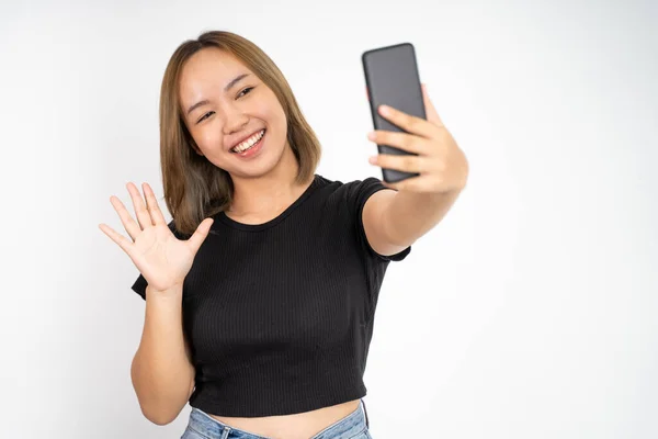Vrouw maken een video gesprek met behulp van mobiele telefoon met hallo gebaar te zeggen — Stockfoto