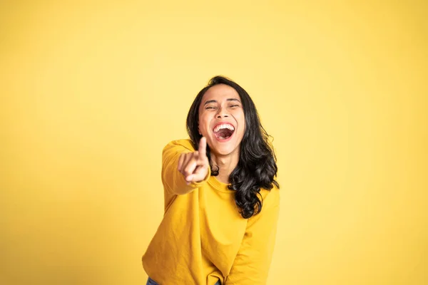 Woman with finger pointing at frong and laughing at something — Stock Photo, Image