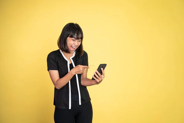 Excited asian woman laugh with finger pointing on her mobile phone — Foto Stock