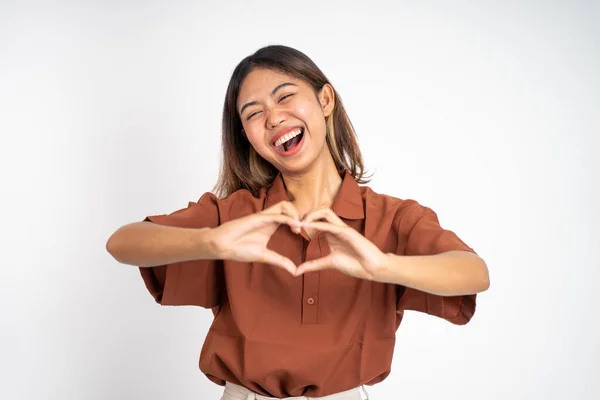 Woman smiling in heart shape with fingers on isolated — Stockfoto