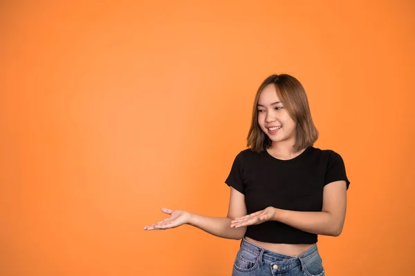 Jovem mulher asiática com gesto de mão apresentando algo — Fotografia de Stock