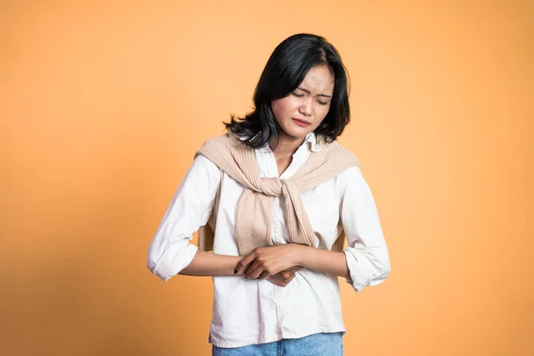 Woman having her period holding her stomach in pain — Fotografia de Stock