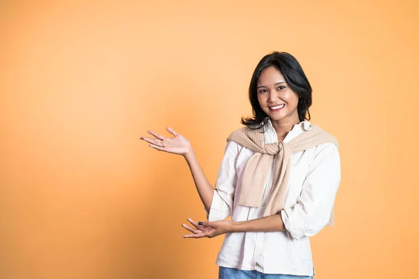 Giovane donna asiatica con gesto della mano che presenta qualcosa — Foto Stock