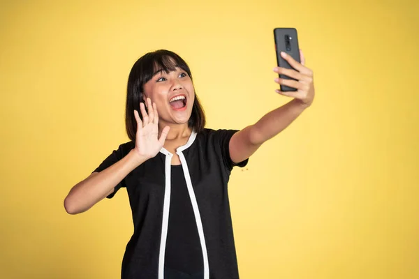 Woman make a video call using mobile phone with saying hello gesture — Foto Stock