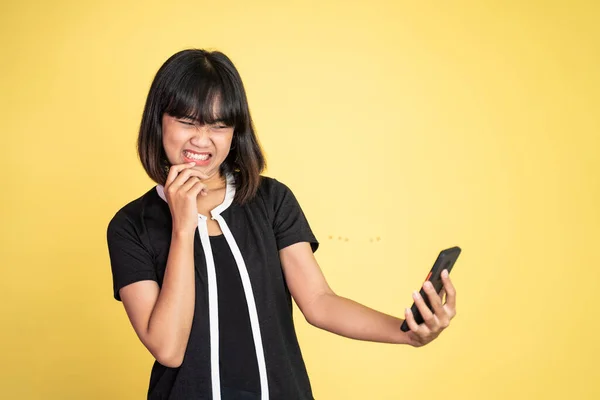 Mad asian young woman while using mobile phone — Stok fotoğraf