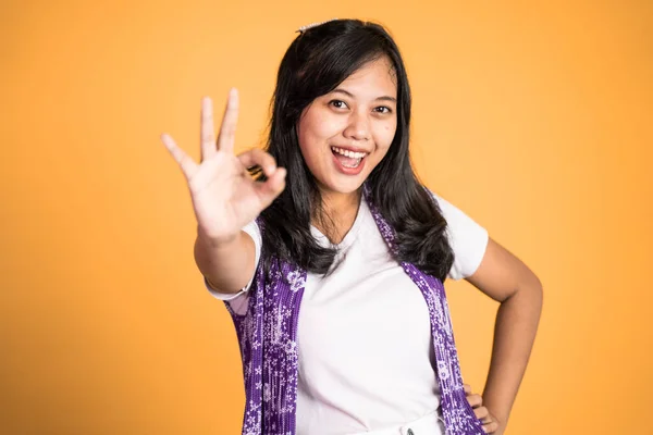 Жінка посміхається з нормальним жестом руки на ізольованому фоні — стокове фото