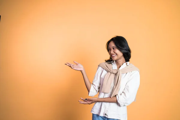 Jonge aziatische vrouw met de hand gebaar presenteren iets — Stockfoto